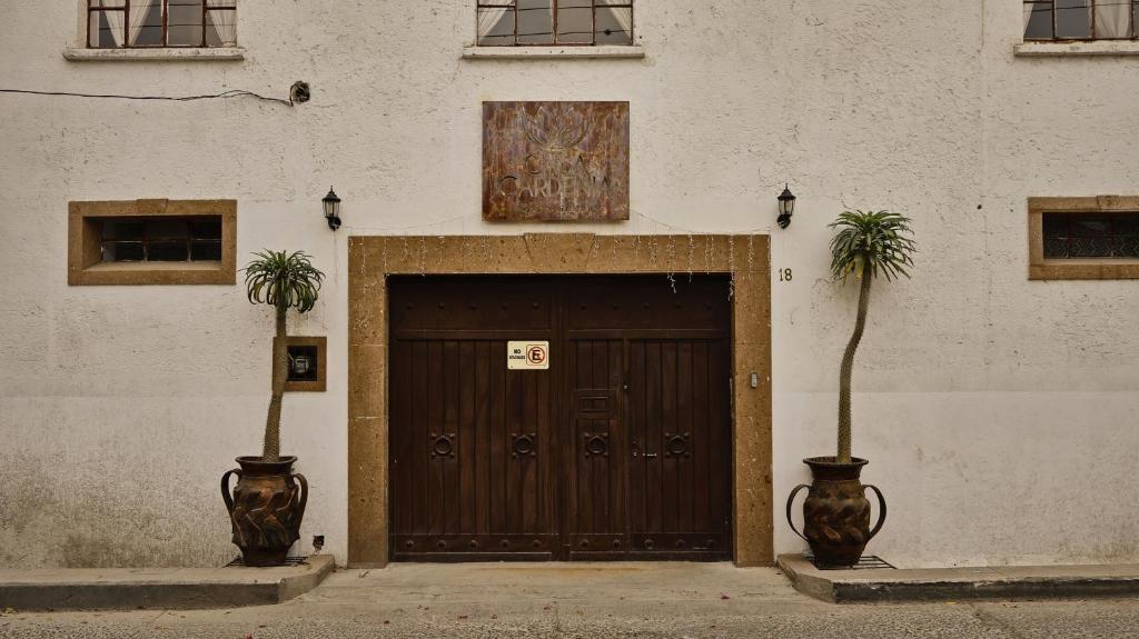 een houten deur met twee palmbomen ervoor bij Casa Gardenia Hotel in Tecozautla