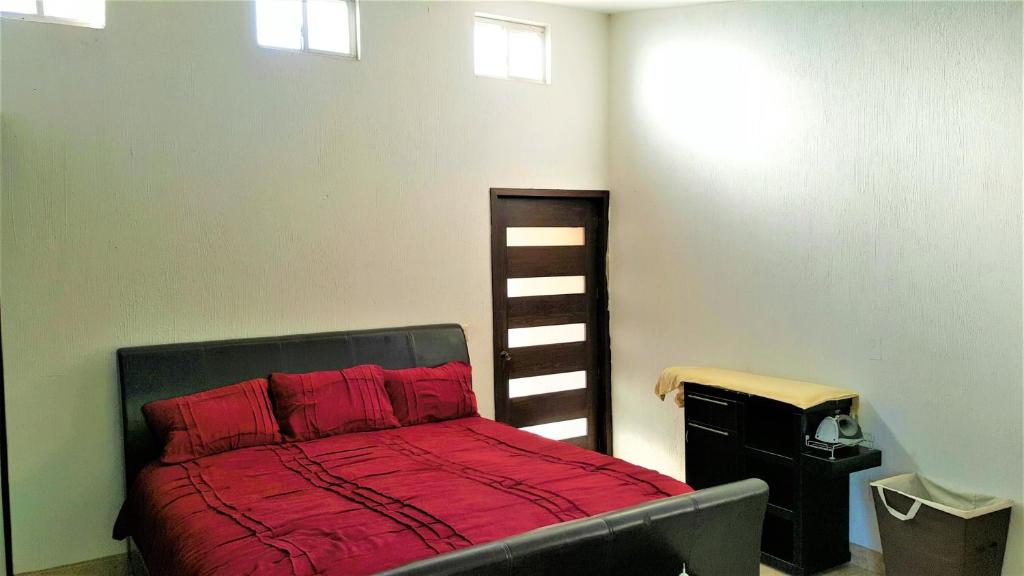 Un dormitorio con una cama con sábanas rojas y una escalera en Casa Jardin, en Guadalajara