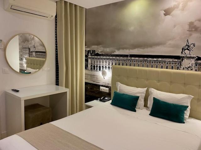 ein Schlafzimmer mit einem großen Bett und einem Spiegel in der Unterkunft Lisbon City Apartments & Suites by City Hotels in Lissabon