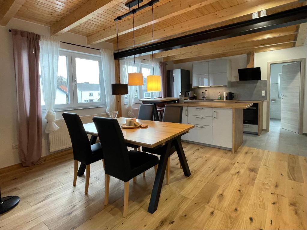 uma cozinha e sala de jantar com uma mesa de madeira e cadeiras em Helles ruhiges Appartement im Grünen em Dortmund