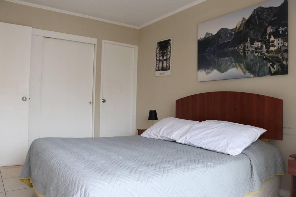 a bedroom with a large bed with a wooden headboard at Confortable depto. en La Serena in La Serena
