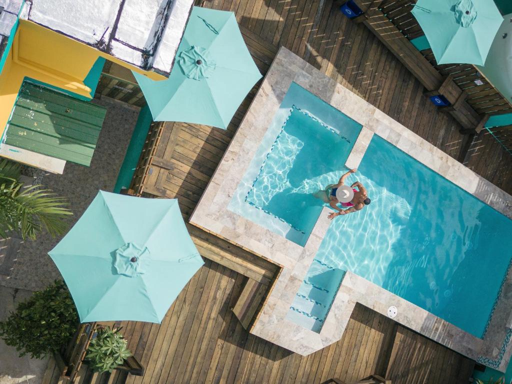 een uitzicht over een zwembad met een persoon in het water bij Hotel Boutique Calizo vip in Fajardo