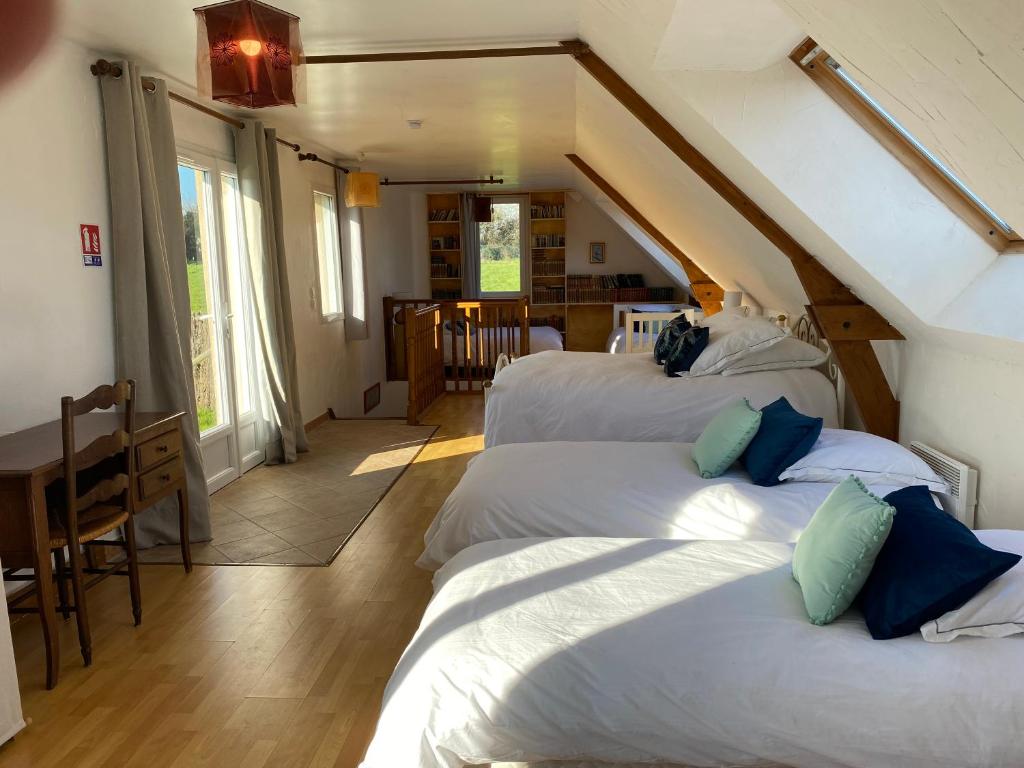 1 dormitorio con 3 camas y comedor con mesa en Gîte Gold au Domaine de Saint Vigor, 