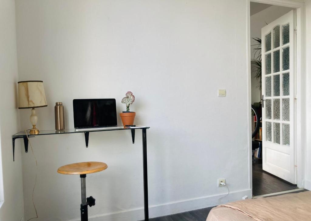 een kamer met een tafel met een tv en een kruk bij APPARTEMENT AU COEUR DES JEUX OLYMPIQUES. in LʼÎle-Saint-Denis