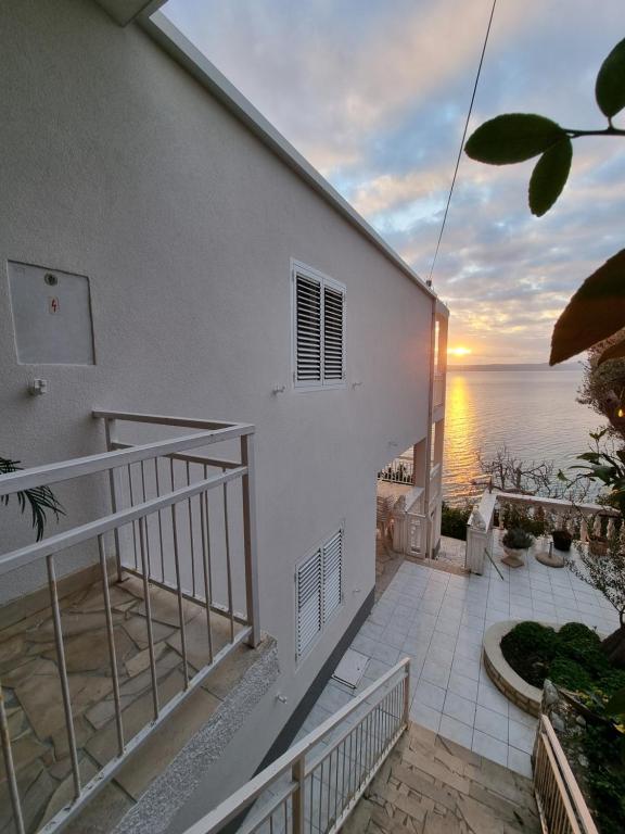 a balcony of a house with a view of the ocean at Apartmani Anda in Živogošće