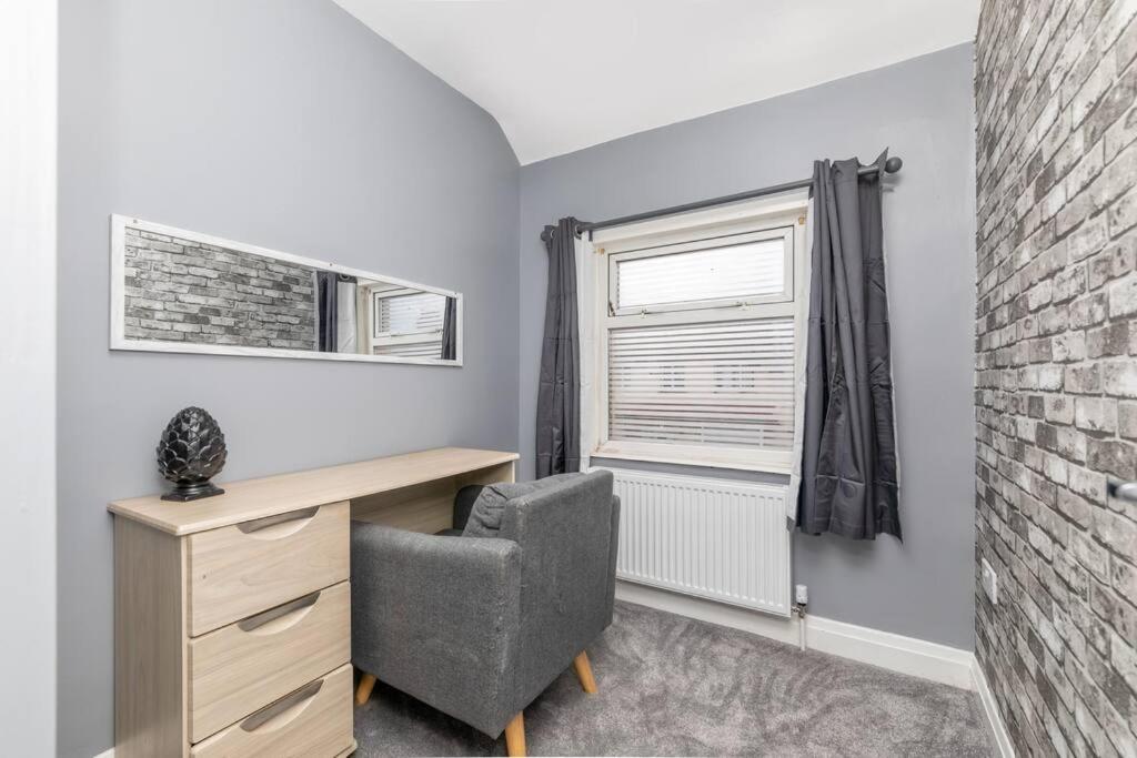 a bedroom with a desk and a chair and a window at Town Centre Town House free WiFi and free on street parking in Middlesbrough