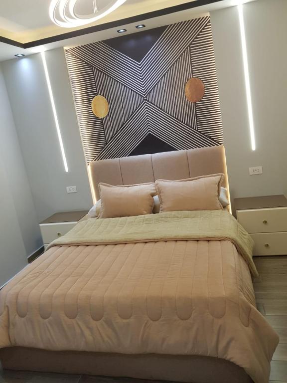 een slaapkamer met een groot bed met een groot hoofdeinde bij الجيزه شارع كليه الزراعه عماره ١٢ in Caïro