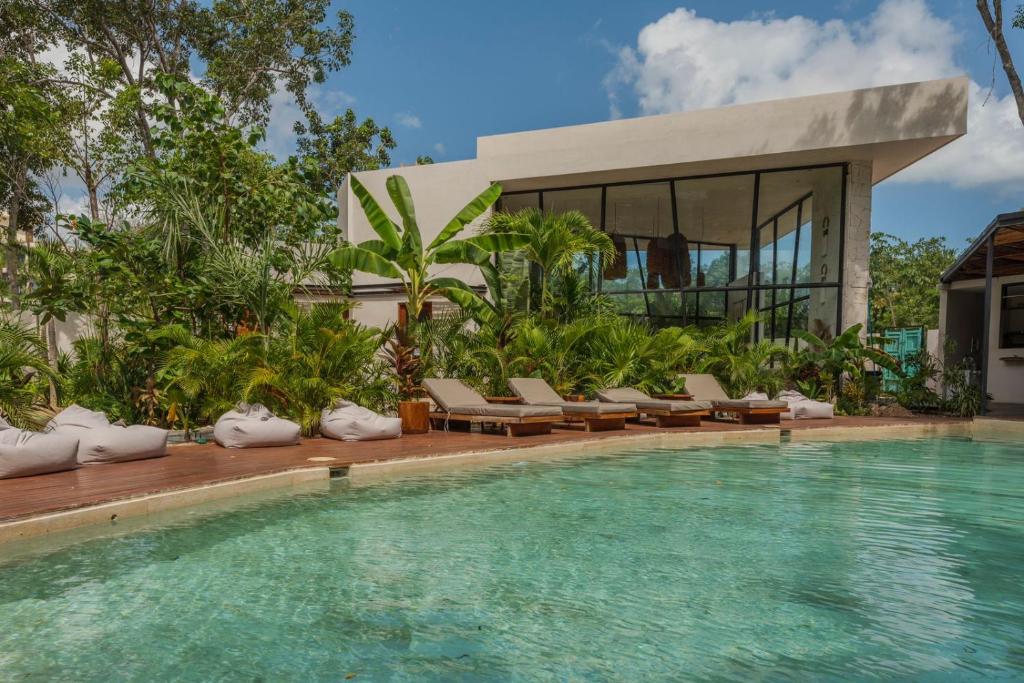 een villa met een zwembad en een huis bij Departamento en Tulum Jade in Tulum