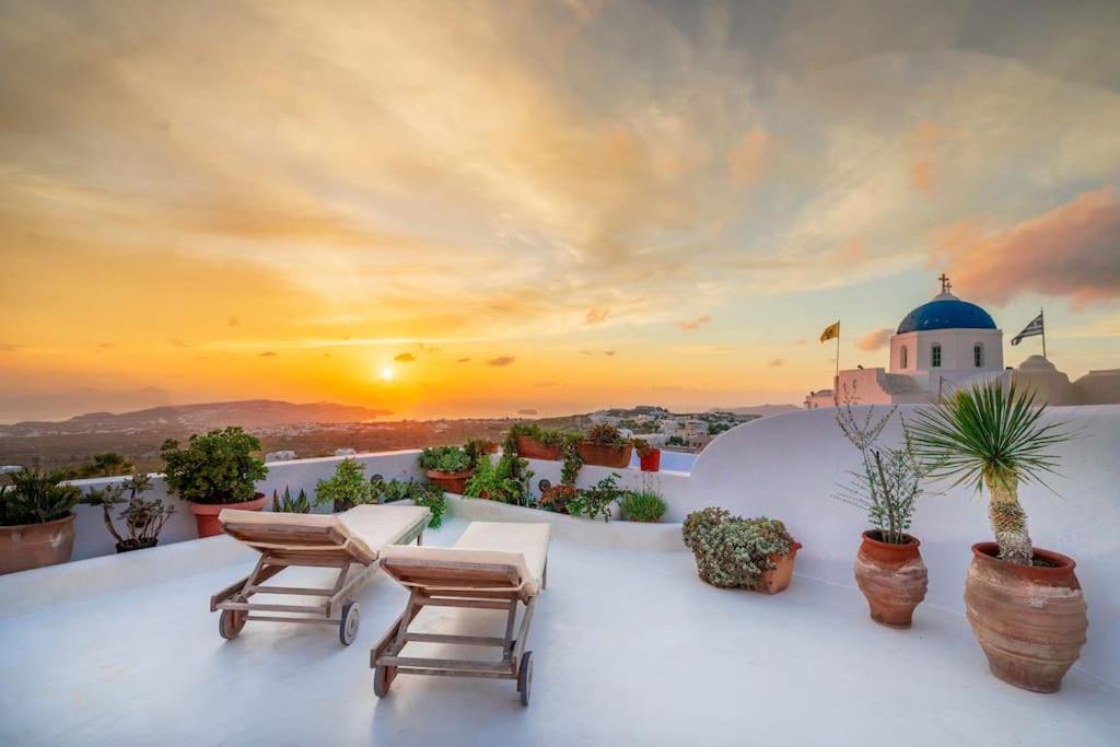 una puesta de sol en el techo de una casa con sillas en Elicriso Villa, en Pirgos