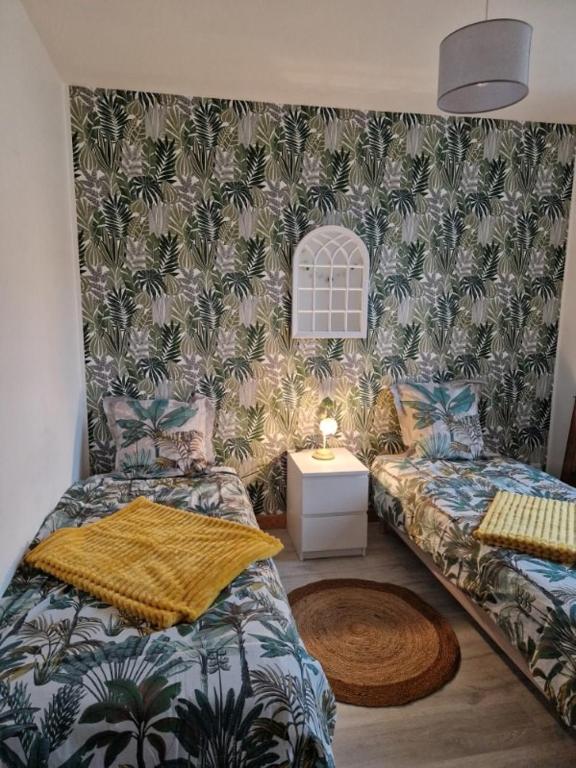 a small room with two beds and a table at Chez Aurélie et Bruno in Montceau-les-Mines