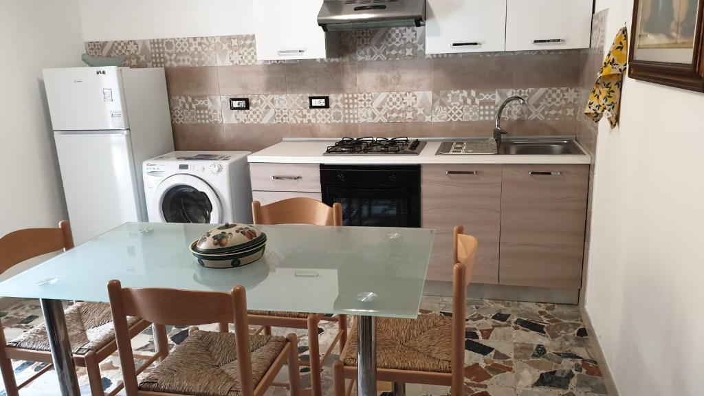 a kitchen with a table and a stove and a refrigerator at Bingo 1 completo in Alghero