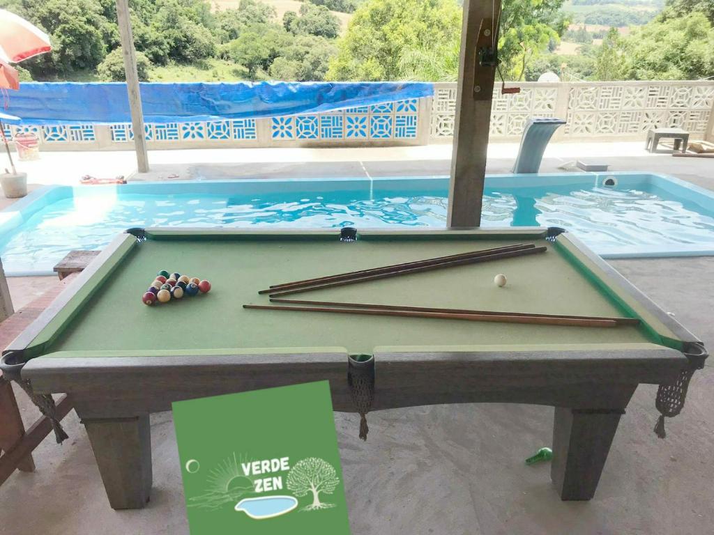 a pool table in front of a swimming pool at Refugio Verde Zen in Dois Vizinhos
