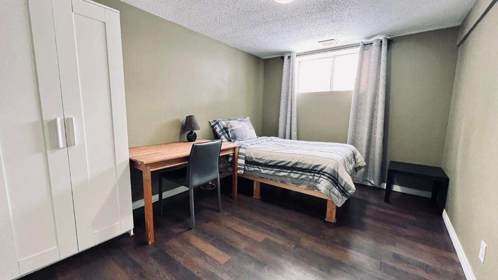 een slaapkamer met een bureau, een bed en een raam bij Private Rooms NAIT Guest House For Men Only in Edmonton