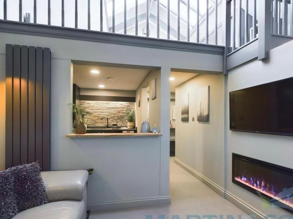 een woonkamer met een bank en een flatscreen-tv bij Spacious open planned 1 bedroom apartment in Burgess Hill