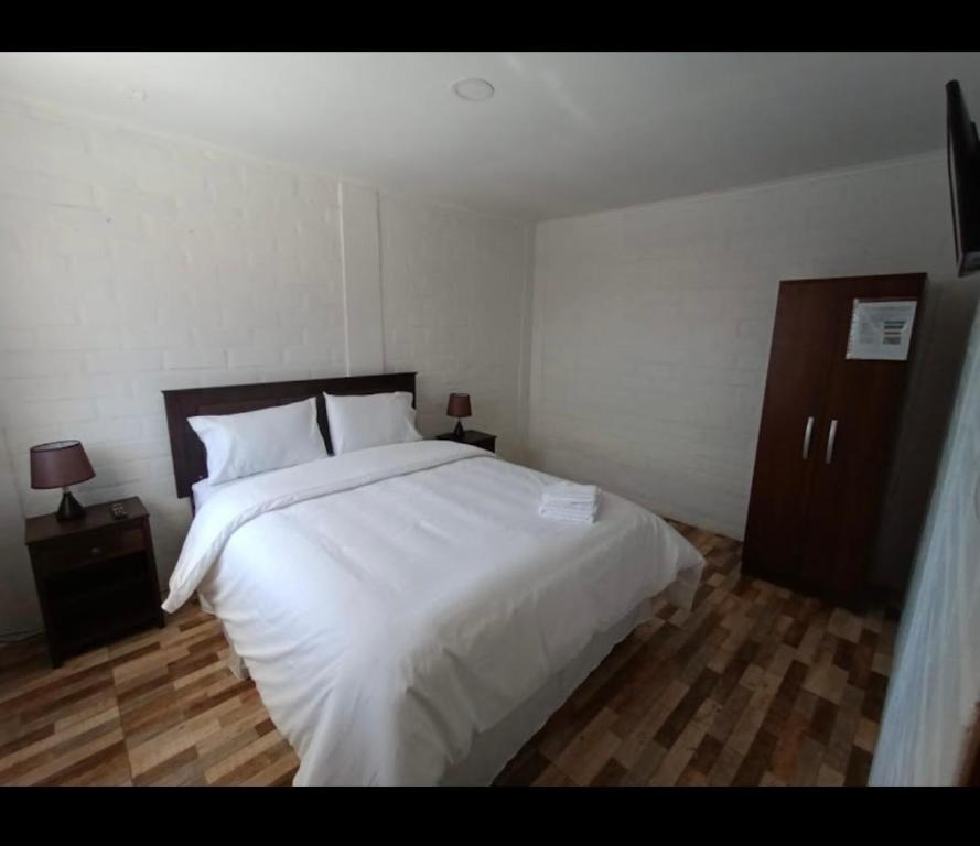 una camera da letto con un grande letto bianco e due comodini di Hotel Santa Emilia Salamanca a Salamanca