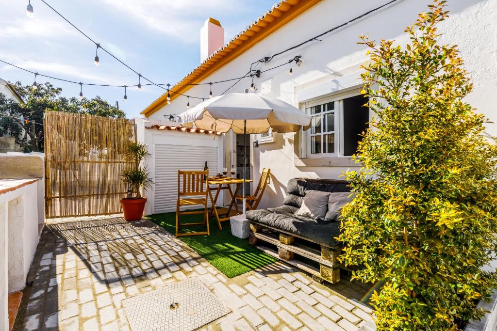 a small patio with a table and an umbrella at MADA HOUSE's in Sesimbra