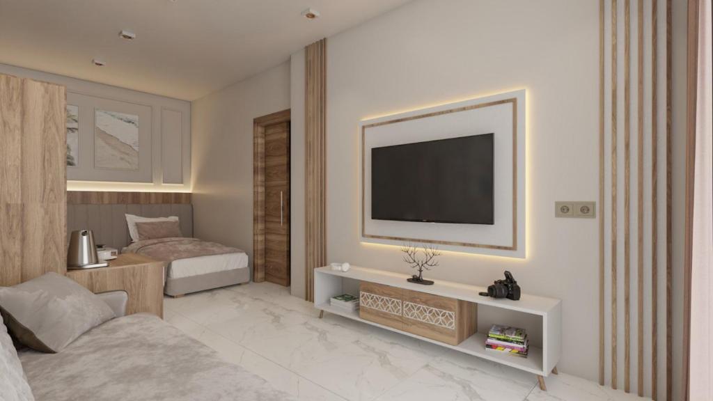 um quarto com uma cama e uma televisão na parede em Crown Residence Belek Health & SPA em Belek