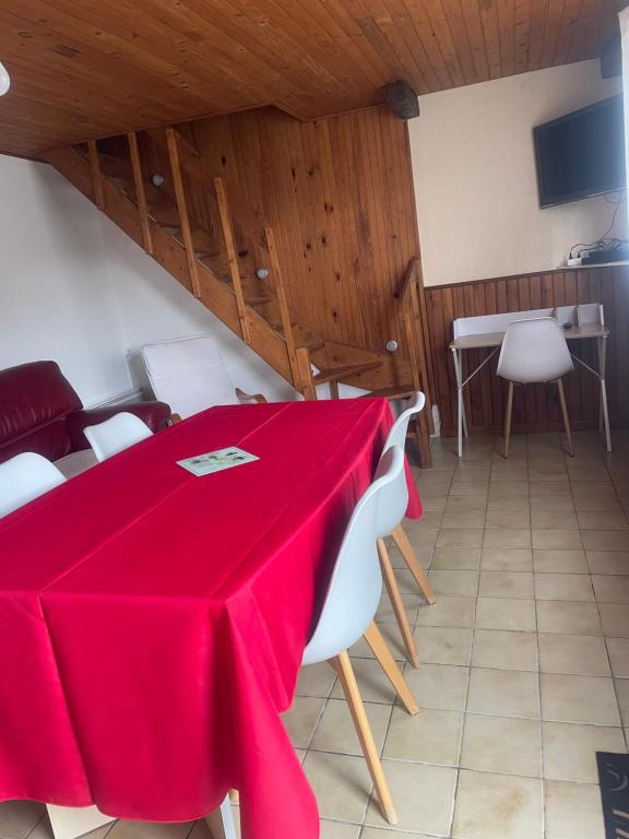 una sala da pranzo con tavolo e sedie rossi di Maison de vacances à louer a Meschers-sur-Gironde