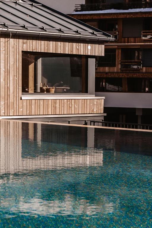 a building next to a pool of water at kerii - adults boutique hotel in Saalbach-Hinterglemm