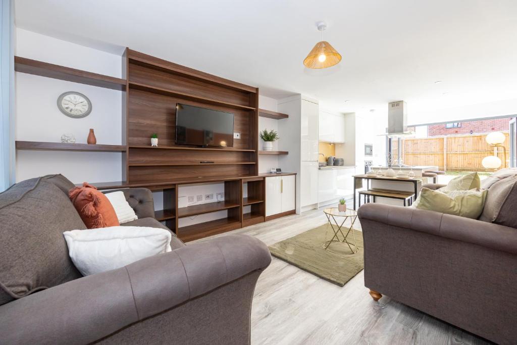 ein Wohnzimmer mit 2 Sofas und einem TV in der Unterkunft Rest&Recharge at Brookdale House (5 Bedrooms, 15mins to City Centre, Free Parking) in Manchester