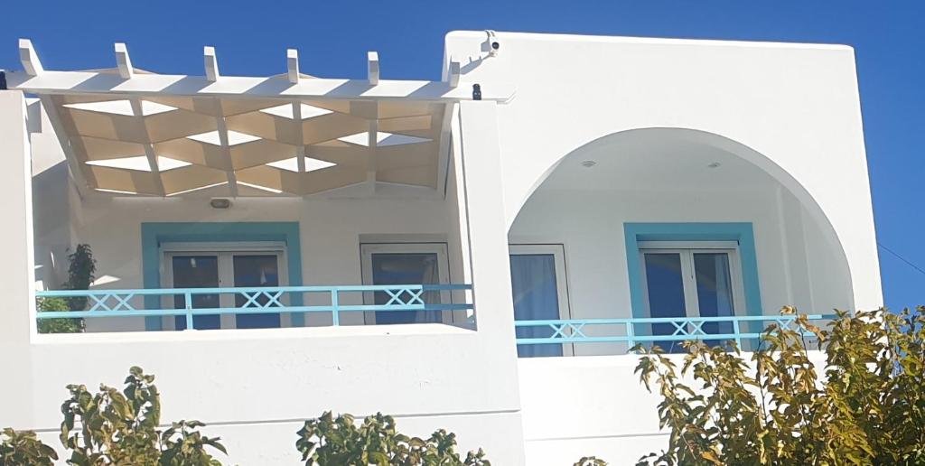 a building with a balcony with a blue railing at Haraki Memories Beach Studios in Haraki