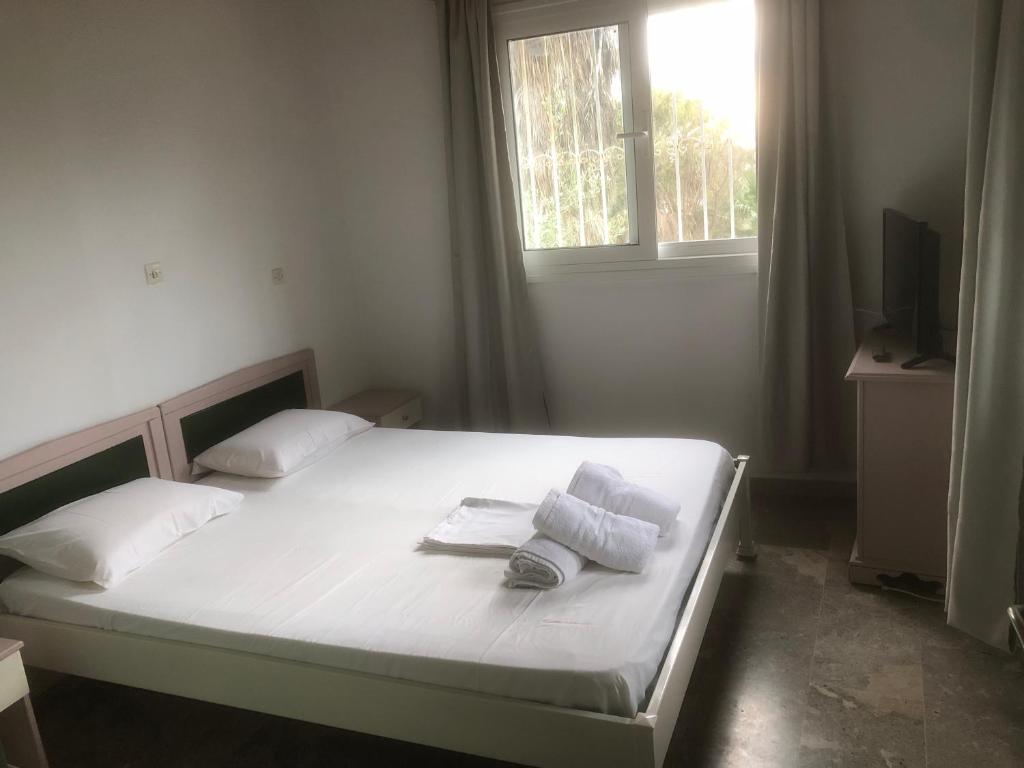 a bedroom with a bed with towels and a window at Barreira Beachfront Rooms 3 in Kalamata