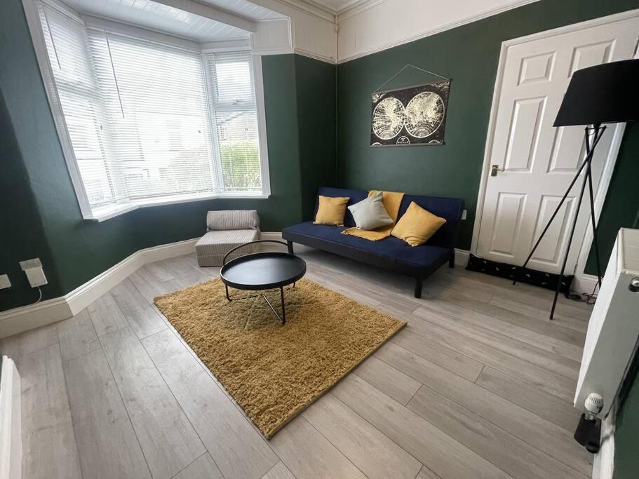Una sala de estar con un sofá azul y una mesa. en Comfy home in Newport, en Newport