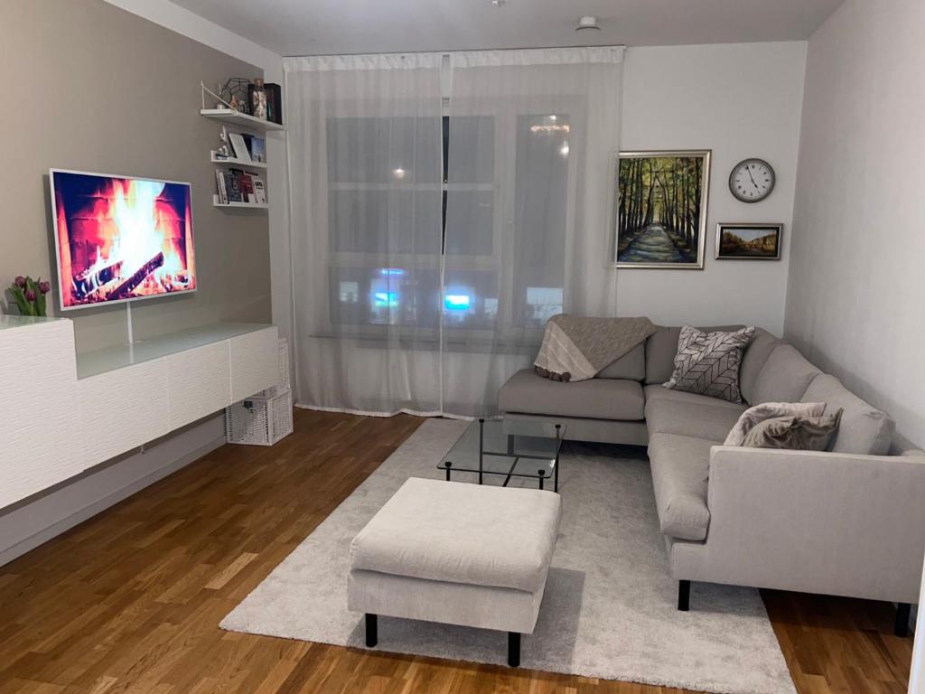 uma sala de estar com um sofá e uma televisão em Hyllie Alle em Malmo