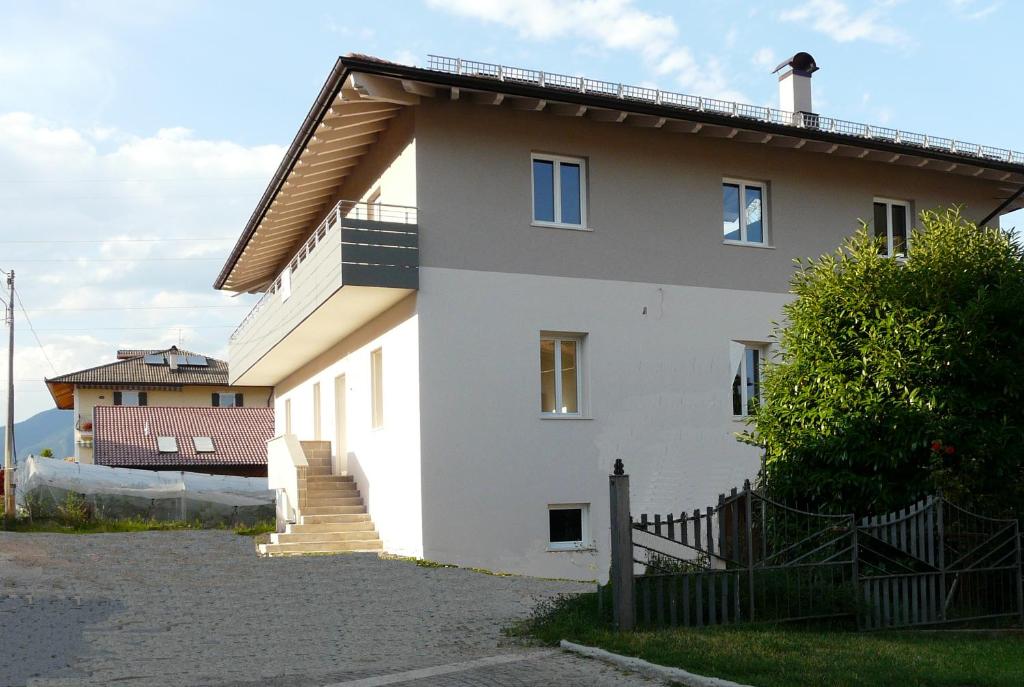 una casa blanca con una valla de madera delante de ella en Cinzia Dolomiti del Brenta, en Tassullo