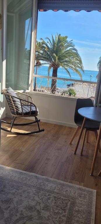 un salon avec une chaise et un palmier dans l'établissement Studio face à la Méditerranée, à Cagnes-sur-Mer