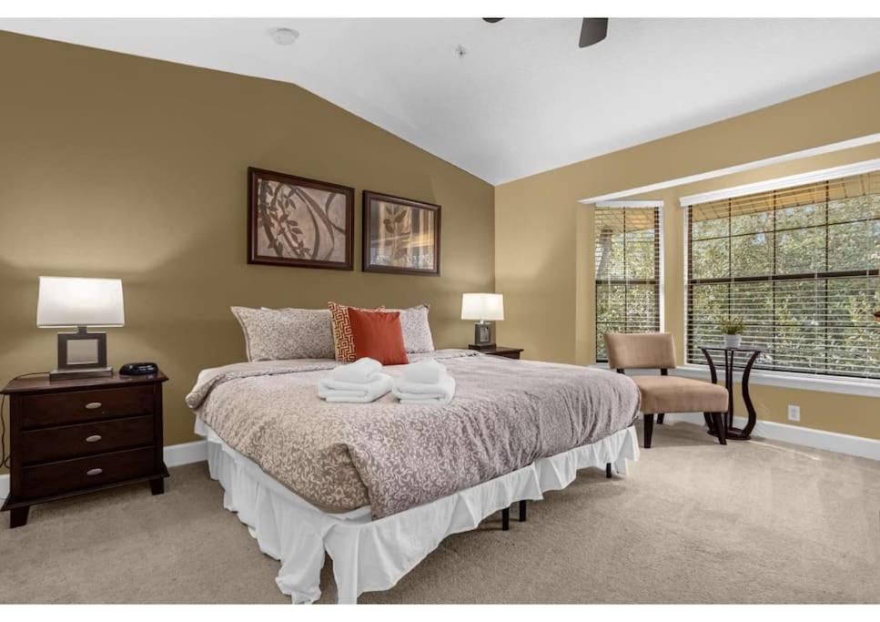 a bedroom with a large bed and a window at Beautiful Townhouse 1 Mile to Disney with Pool, Gym, & Jacuzzi in Orlando