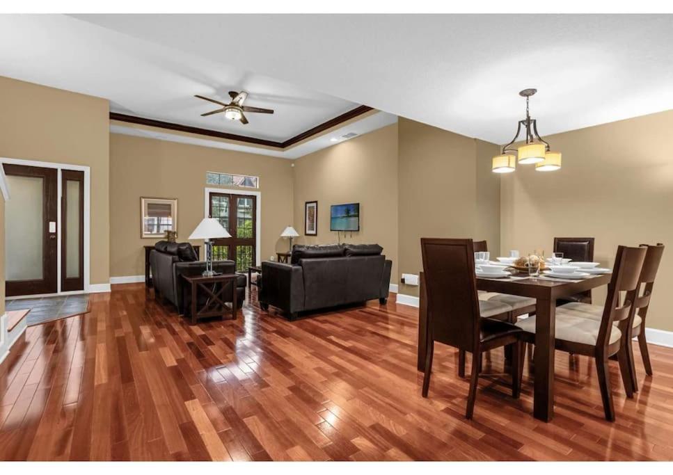 a dining room and living room with a table and chairs at 4BR 4 Baths Townhouse 1 Mile to Disney with Pool, Gym, & Jacuzzi in Orlando