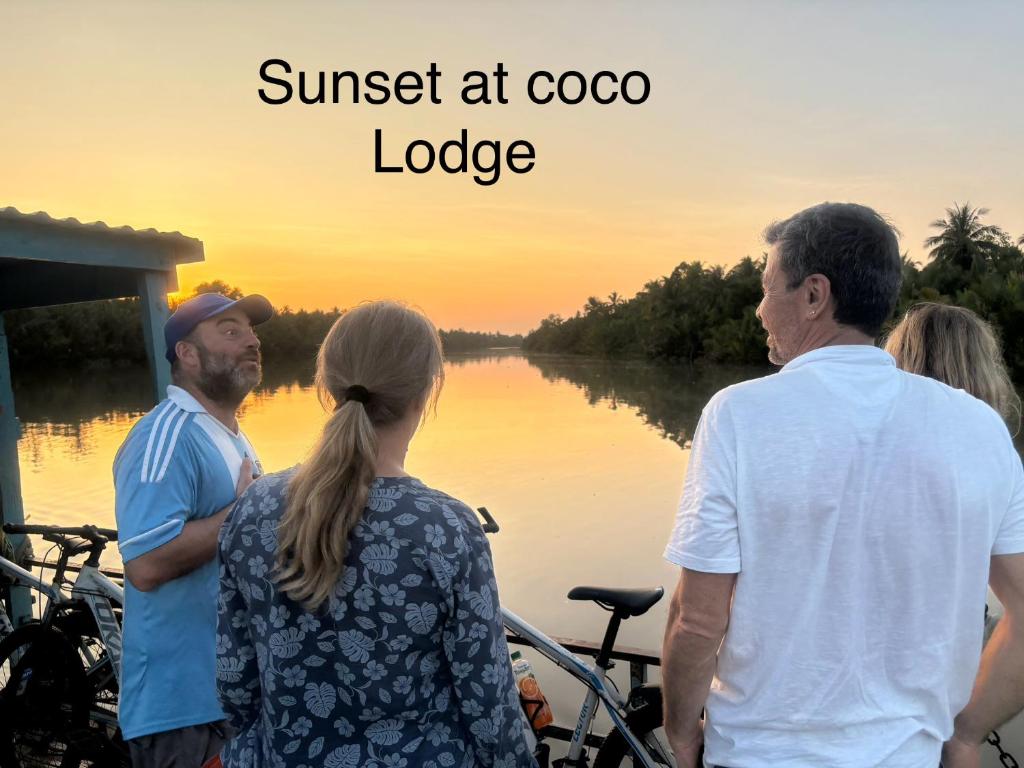 een groep mensen die naast een rivier staan bij Bentre Coco Lodge in Ben Tre