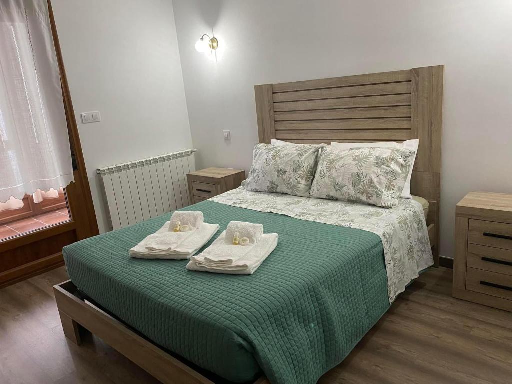 een slaapkamer met een bed met twee handdoeken erop bij Fraga de Pitões in Pitões das Júnias