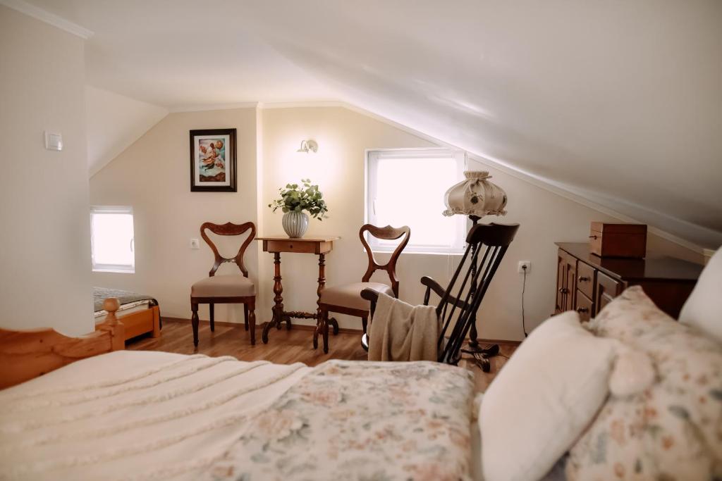 a bedroom with a bed and two chairs and a table at Ranch 170 in Subotica