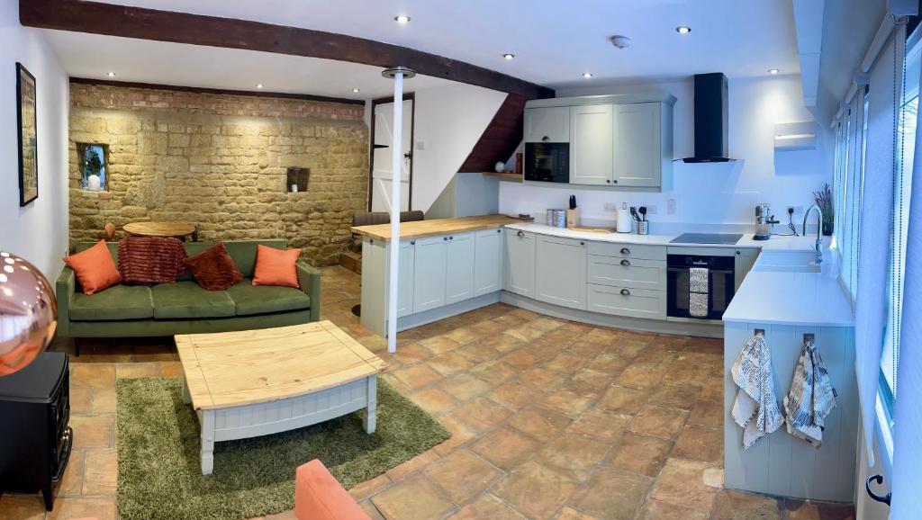 a kitchen and living room with a couch and a table at Little House Annexe in Shotteswell