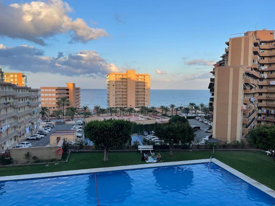 Blick auf ein Schwimmbad in einer Stadt mit Gebäuden in der Unterkunft APARTAMENTO ARENALES BELLAVISTASOLYMAR in Arenales del Sol