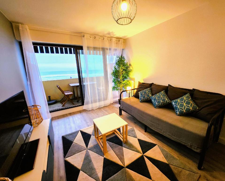 a living room with a couch and a view of the ocean at Appartement vue océan in Lacanau-Océan
