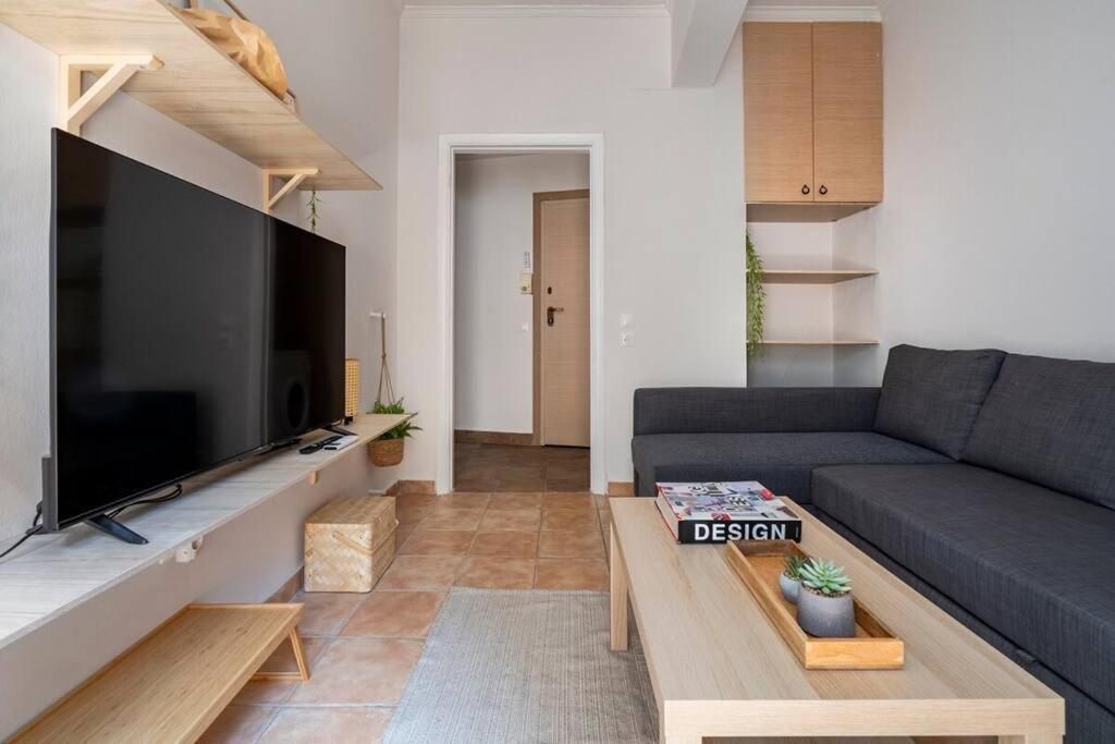 een woonkamer met een bank en een grote flatscreen-tv bij STM Monastiraki Acropolis Apt in Athene