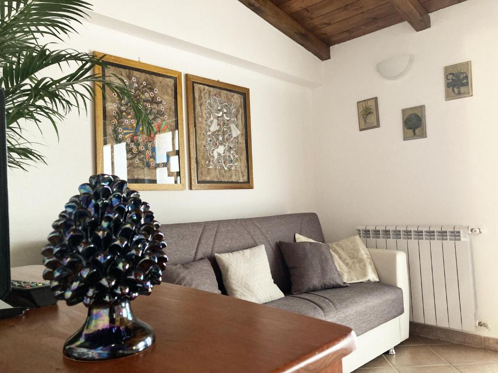 ein Wohnzimmer mit einem Sofa und einem Tisch in der Unterkunft Casa Marlù in Taormina