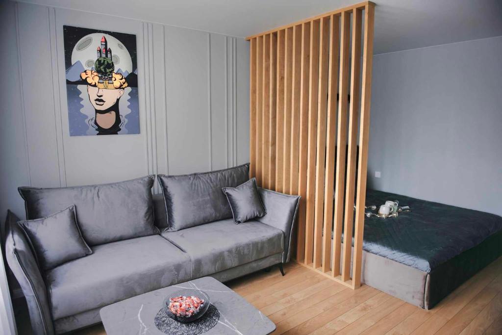 uma sala de estar com um sofá e uma cama em JAUKI STUDIJA KRETINGOS CENTRE em Kretinga