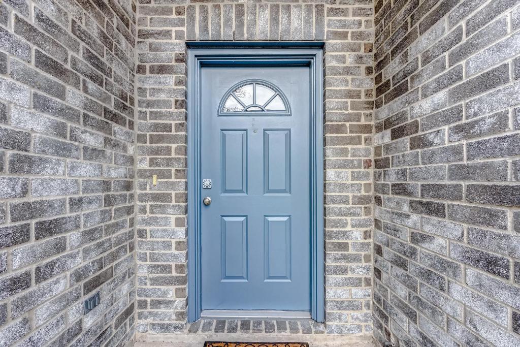 ヒューストンにあるHouston Blue Houseの煉瓦壁の青い扉