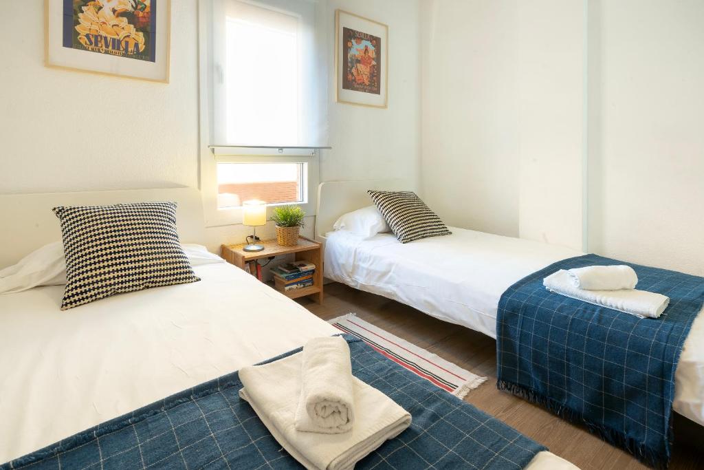 1 Schlafzimmer mit 2 Betten und einem Fenster in der Unterkunft HOME@PORVENIR VFT/SE/03555 in Sevilla