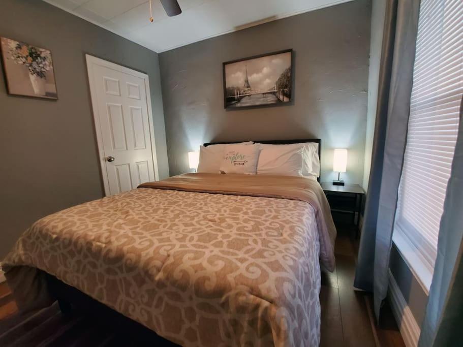 a bedroom with a bed and a window and a door at Modern Getaway, Single Bedroom Full Apartment in Niagara Falls