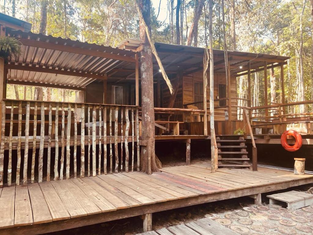 a cabin in the woods with a wooden deck at Cabana tucuxi in Novo Airão