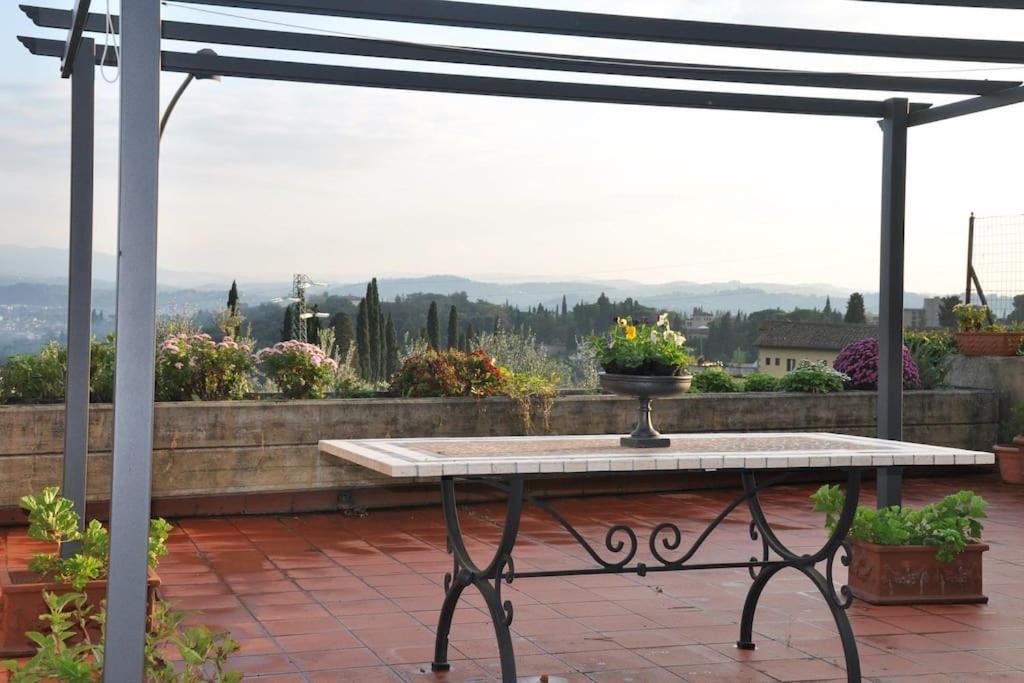 un tavolo su un patio con pergolato di ☆Lovely view of Florence in Stilish Designed Apt☆ a Fiesole