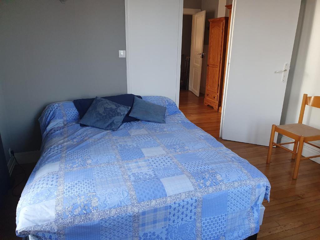 Una cama azul y blanca en una habitación en 2 chambres à 10 min du centre de Paris, en Bois-Colombes