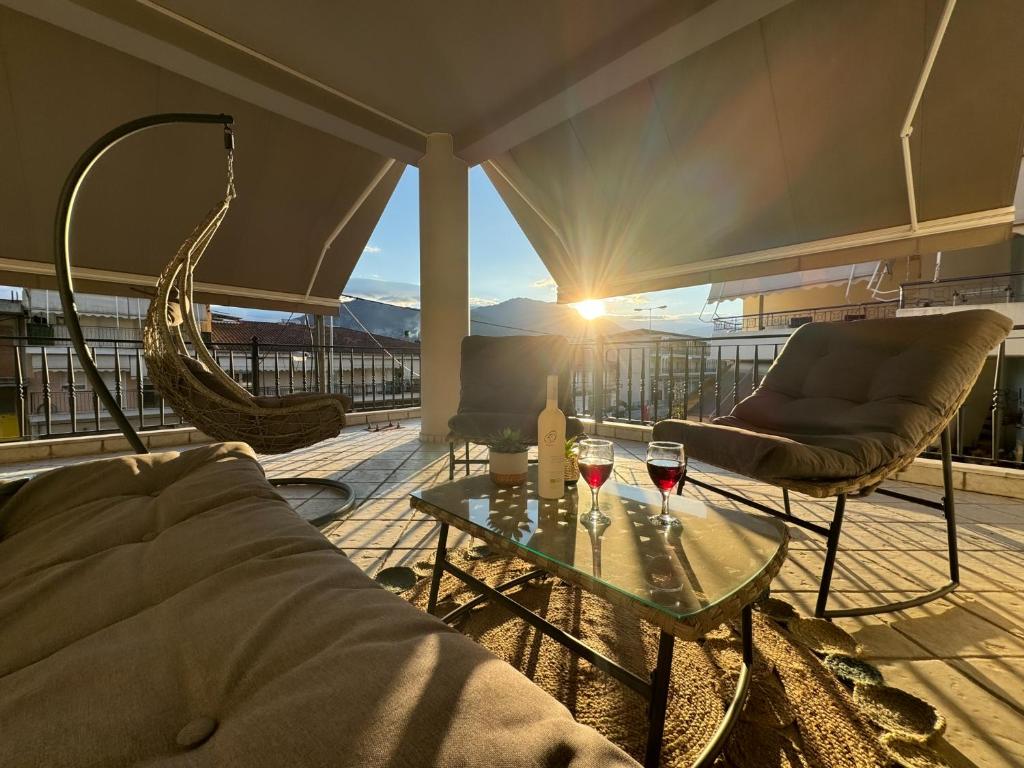 a living room with a couch and two glasses of wine at Mystique Boutique Residence in Kalabaka