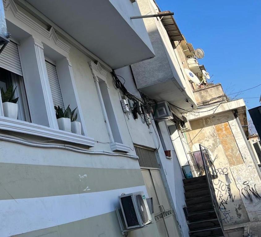 ein weißes Gebäude mit einem Fenster und einem Balkon in der Unterkunft Franci's Apartment no.3 in Tirana