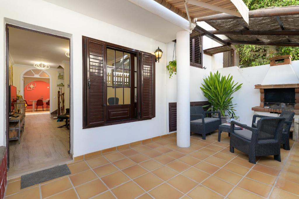 a patio with chairs and a fireplace in a house at Casa Fantástica in Playa Honda